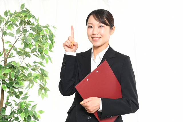 指をさす制服の女性